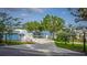 A spacious driveway with a two-story home with balcony and lake view at 36607 E Eldorado Lake Dr, Eustis, FL 32736