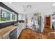 A kitchen features stone floors and white cabinets with granite countertops and black tile backsplash at 36607 E Eldorado Lake Dr, Eustis, FL 32736