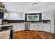 A kitchen features stone floors and white cabinets with granite countertops and black tile backsplash at 36607 E Eldorado Lake Dr, Eustis, FL 32736