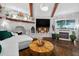 Living room with fireplace, exposed beams, water view, and modern decor at 36607 E Eldorado Lake Dr, Eustis, FL 32736
