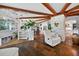 Bright living room featuring stone accents, wood-beam ceilings, and a modern spiral staircase at 36607 E Eldorado Lake Dr, Eustis, FL 32736