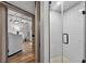 Modern shower with white tile, glass door, and pebble floor, adjoining the laundry room at 36607 E Eldorado Lake Dr, Eustis, FL 32736