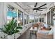 A sunroom with tile flooring, large windows with lake views, and comfortable seating at 36607 E Eldorado Lake Dr, Eustis, FL 32736