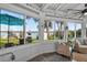 A sunroom with tile flooring, lake views through large windows, and casual seating at 36607 E Eldorado Lake Dr, Eustis, FL 32736