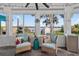 A sunroom offers lake views, cozy seating, and natural light at 36607 E Eldorado Lake Dr, Eustis, FL 32736