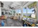 Spacious sunroom with tile flooring, plush seating, and large windows offering beautiful views of the lake at 36607 E Eldorado Lake Dr, Eustis, FL 32736