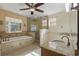 Bright bathroom featuring a soaking tub, glass shower, and granite countertops at 4200 Joslyn Ln, Lady Lake, FL 32159