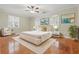 Furnished bedroom with hardwood floors, ceiling fan, and three windows with shutters at 4200 Joslyn Ln, Lady Lake, FL 32159