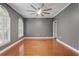 Spacious bedroom features grey walls, hardwood floors, white trim, and a modern ceiling fan at 4200 Joslyn Ln, Lady Lake, FL 32159