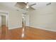 Bedroom with hardwood floors, ceiling fan, and door leading to the bathroom at 4200 Joslyn Ln, Lady Lake, FL 32159