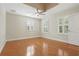 Bedroom with hardwood floors, ceiling fan, and two windows with shutters at 4200 Joslyn Ln, Lady Lake, FL 32159