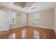 Bedroom with hardwood floors, ceiling fan, and three windows with shutters at 4200 Joslyn Ln, Lady Lake, FL 32159