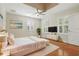 Furnished bedroom with hardwood floors, ceiling fan, and two windows with shutters at 4200 Joslyn Ln, Lady Lake, FL 32159