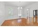 Bright dining room with hardwood floors, arched windows, and elegant chandelier lighting at 4200 Joslyn Ln, Lady Lake, FL 32159