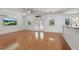 Bright living room featuring hardwood floors, white walls, and double doors to the porch at 4200 Joslyn Ln, Lady Lake, FL 32159