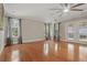 Bright living room with wood floors, large windows, and ceiling fan at 4200 Joslyn Ln, Lady Lake, FL 32159