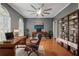 Stylish home office with gray walls, hardwood floors, modern fan, and custom shelving at 4200 Joslyn Ln, Lady Lake, FL 32159