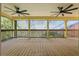 Relaxing screened patio featuring two ceiling fans, views of the pool area, and wood flooring at 4200 Joslyn Ln, Lady Lake, FL 32159
