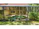 Enclosed pool area with lush tropical plants, rock accents, and a two-story home in the background at 4200 Joslyn Ln, Lady Lake, FL 32159