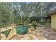 Beautiful enclosed pool area with rock features, lush landscaping, spa, and stone tile decking at 4200 Joslyn Ln, Lady Lake, FL 32159