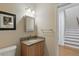 Convenient powder room featuring a granite vanity, framed mirror, and modern lighting fixtures at 4200 Joslyn Ln, Lady Lake, FL 32159