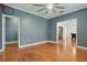 Inviting room with blue walls, hardwood floors, white trim, and a modern ceiling fan at 4200 Joslyn Ln, Lady Lake, FL 32159