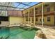 Spacious pool and patio area with lush landscaping, rock features, a screened enclosure, and multi-level decks at 4200 Joslyn Ln, Lady Lake, FL 32159