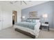 This primary bedroom has a luxurious king bed, a soft blue accent wall, and an ensuite bath at 464 W Plant St, Winter Garden, FL 34787