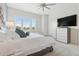 Bright bedroom with a large bed, television, dresser, and bright sunny windows at 464 W Plant St, Winter Garden, FL 34787