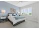 Calming bedroom features a light blue accent wall and large window with wooded view at 464 W Plant St, Winter Garden, FL 34787