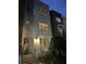 Charming three-story brick townhouse featuring a welcoming front entrance and illuminated windows at twilight at 464 W Plant St, Winter Garden, FL 34787
