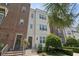 Inviting multi-story townhome featuring brick and white brick, with an entryway framed by manicured greenery at 464 W Plant St, Winter Garden, FL 34787