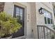 Close-up of the front door featuring a modern glass-paneled door, stylish exterior lantern, and manicured greenery at 464 W Plant St, Winter Garden, FL 34787