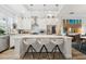 Bright kitchen featuring white cabinetry, stainless steel appliances, large island with bar seating and decorative pendant lighting at 464 W Plant St, Winter Garden, FL 34787