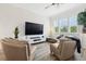 This bright living room features a large TV, a large window, and a leather chairs and sectional at 464 W Plant St, Winter Garden, FL 34787