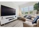 This living room features a large TV, a large window, and a leather curved sectional at 464 W Plant St, Winter Garden, FL 34787