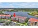 Waterfront condo building with red tile roof, tropical landscaping, and parking at 5024 Shoreway Loop # 10106, Orlando, FL 32819