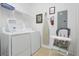 Organized laundry room with a washer, dryer, shelving, ironing board, and baby chair at 5024 Shoreway Loop # 10106, Orlando, FL 32819