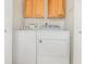 A laundry room with wooden cabinets and a white washer and dryer at 546 Northbridge Dr, Altamonte Springs, FL 32714