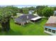 Aerial view of house showcasing a well-maintained lawn, screened-in porch, and chain link fence at 5929 Hatteras Dr, Port Orange, FL 32127