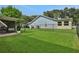View of backyard with lush green grass, screened patio, and black chain link fence at 5929 Hatteras Dr, Port Orange, FL 32127