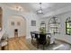 Bright dining room featuring an overhead chandelier, arched windows, and hardwood floors at 5929 Hatteras Dr, Port Orange, FL 32127