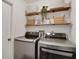 Laundry room features modern washer and dryer units and stylish shelving for organized storage solutions at 5929 Hatteras Dr, Port Orange, FL 32127