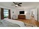 Bright main bedroom with a ceiling fan, dresser with TV, and a cozy armchair, perfect for relaxation at 5929 Hatteras Dr, Port Orange, FL 32127