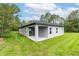 The back of the home shows a covered patio and well-manicured lawn, enhancing outdoor living at 6929 Sw 130Th Lane Rd, Ocala, FL 34473