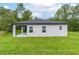 The backyard view shows a well-maintained lawn and the home's exterior with a covered patio at 6929 Sw 130Th Lane Rd, Ocala, FL 34473