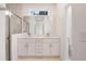 Bathroom with dual vanity, framed mirror, tiled shower, and modern fixtures at 6929 Sw 130Th Lane Rd, Ocala, FL 34473