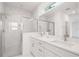 Bathroom showcasing double vanity with marble countertops, framed mirror, and glass enclosed shower at 6929 Sw 130Th Lane Rd, Ocala, FL 34473