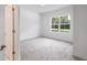 Bright, carpeted bedroom featuring a large window with natural light at 6929 Sw 130Th Lane Rd, Ocala, FL 34473
