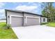 Spacious two-car garage featuring stone accents and a well-maintained lawn at 6929 Sw 130Th Lane Rd, Ocala, FL 34473